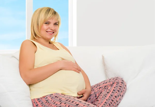 Pregnant woman in bed with red hearts — Stock Photo, Image