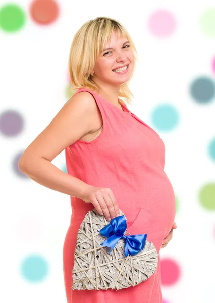 Беременная женщина с сердцем и голубым луком — стоковое фото