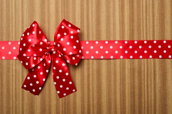 Red bow on wood background — Stock Photo, Image