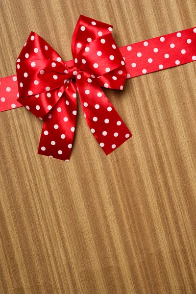 Red bow on wood background — Stock Photo, Image