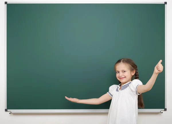 Schoolmeisje in de buurt van schoolbestuur — Stockfoto