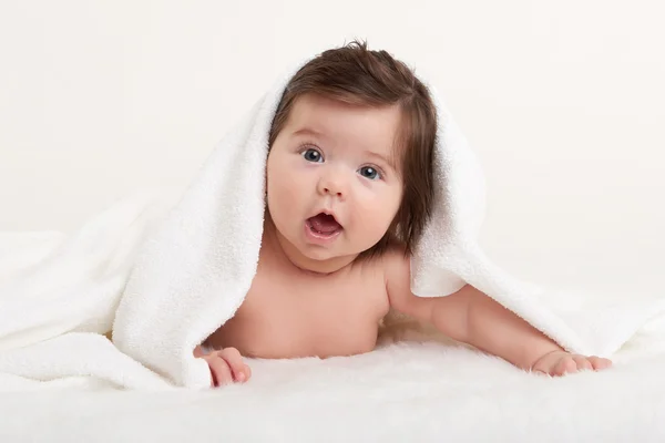 Happy baby under towel on white — Stock Photo, Image