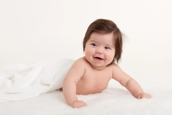 Šťastné dítě pod ručník na bílém pozadí — Stock fotografie