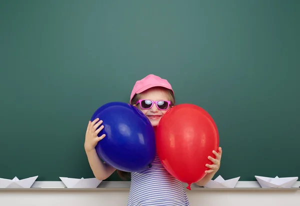 Menina com balão perto da placa da escola — Fotografia de Stock