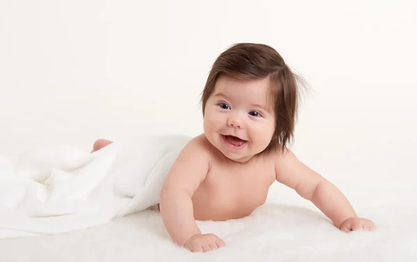 Happy baby under towel on white — Stock Photo, Image