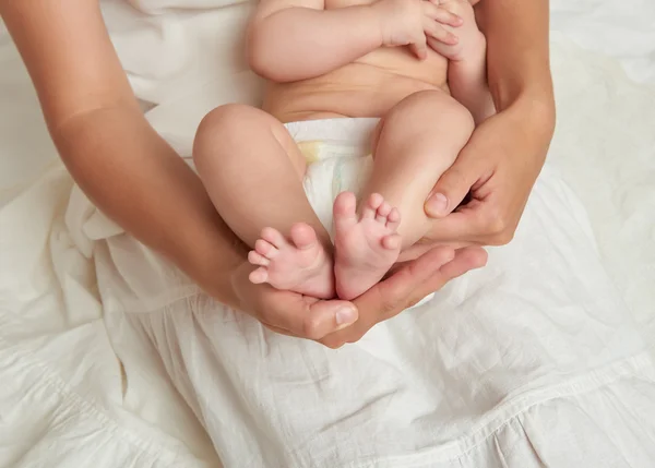 Dětské nohy v rukou matka na bílém pozadí — Stock fotografie