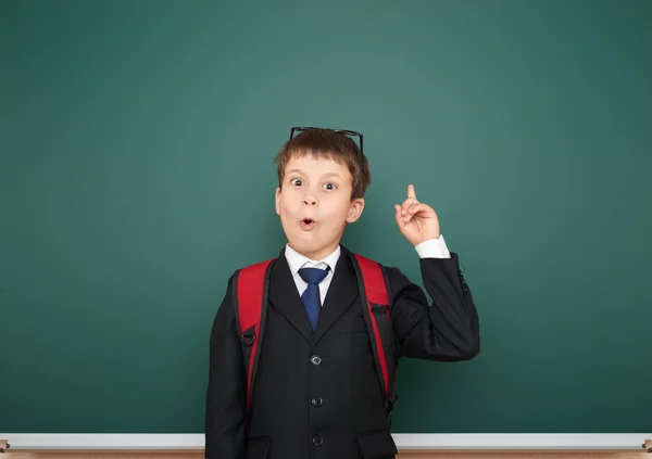 Schooljongen met rugzak op schoolbestuur achtergrond — Stockfoto