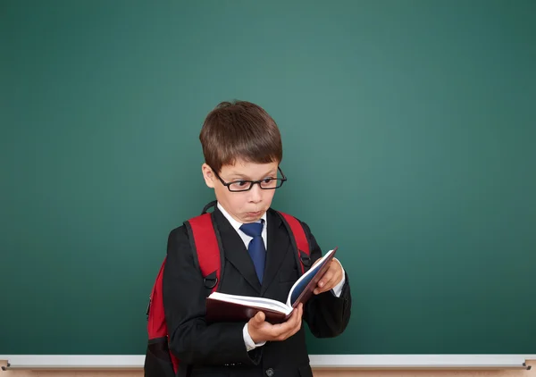 Schoolboy with backpack on school board background — Stock Photo, Image