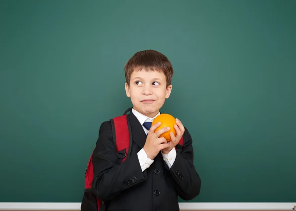 Schüler mit Orange und der Schultafel — Stockfoto