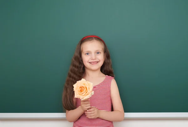 Ragazza con fiore di rosa vicino al consiglio scolastico — Foto Stock