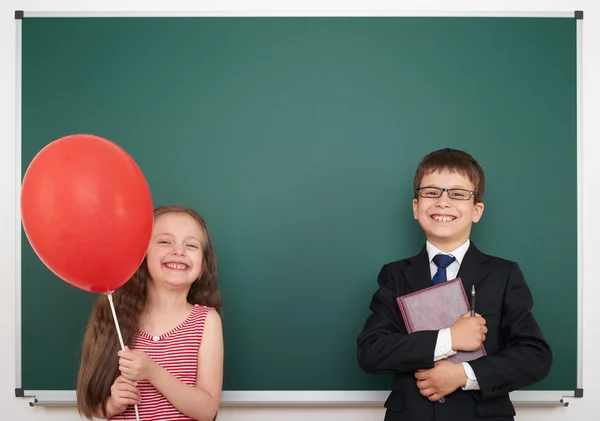 Хлопчик і дівчинка біля шкільної дошки — стокове фото