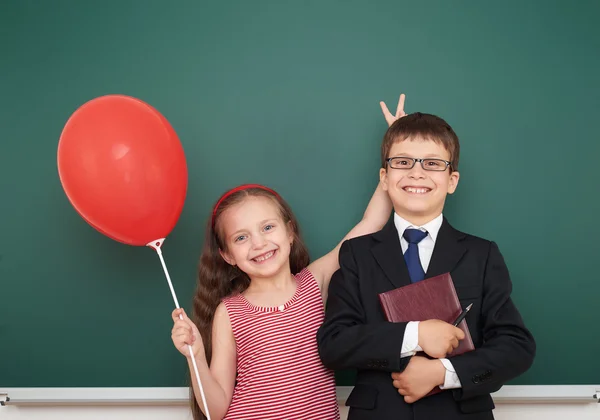 Garçon et fille près de conseil scolaire — Photo