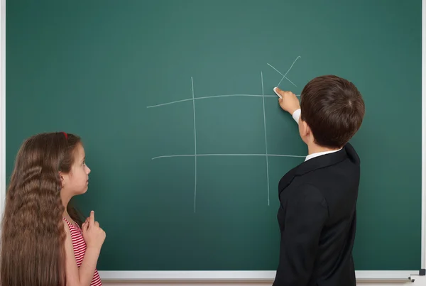 Boy and girl near school board — Stock Photo, Image