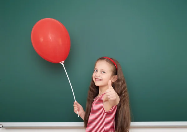 Girl with balloon near school board — Stock Photo, Image