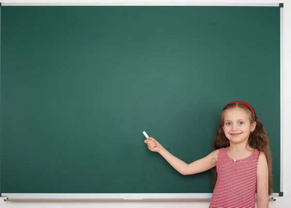 Schoolgirl write on school board — Stock Photo, Image
