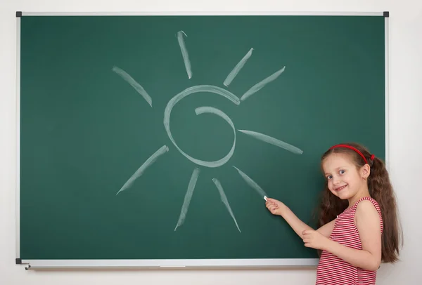 Flicka ritning solen på skolans styrelse — Stockfoto