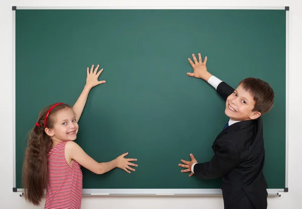 Chlapec a dívka psát na školní tabuli — Stock fotografie