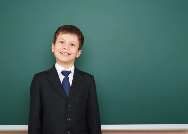 Skolan pojke stående nära styrelse — Stockfoto