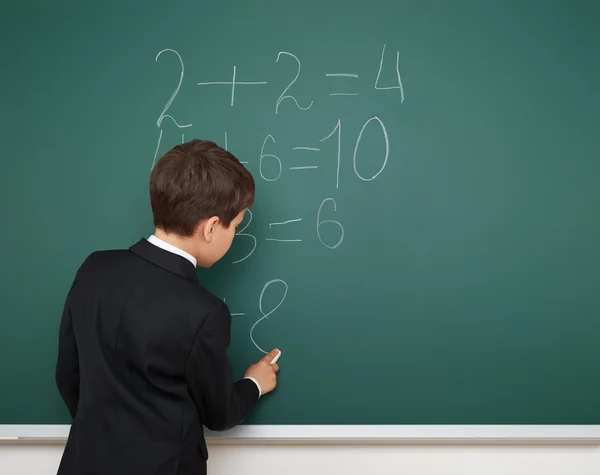 Menino da escola resolver matemática no conselho da escola — Fotografia de Stock