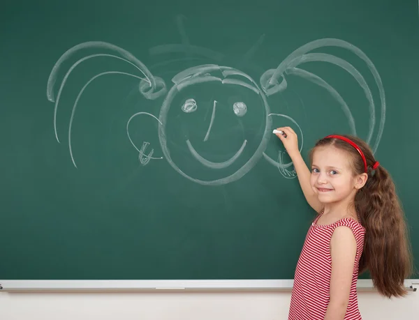 Mädchen zeichnet auf Schultafel — Stockfoto