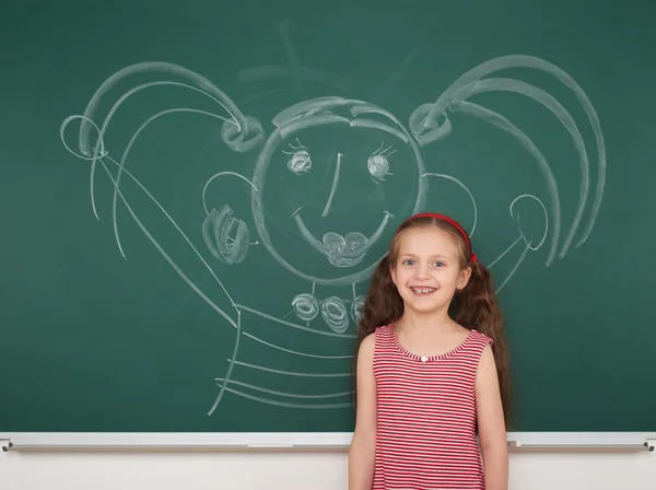 Mädchen zeichnet auf Schultafel — Stockfoto