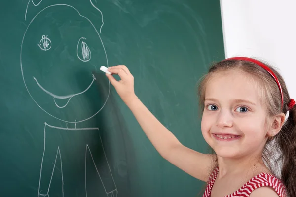 Mädchen zeichnet auf Schultafel — Stockfoto