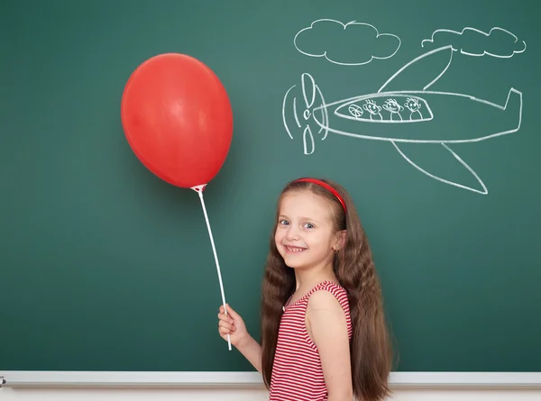 Mädchen mit Luftballon-Zeichenflugzeug auf Schultafel — Stockfoto