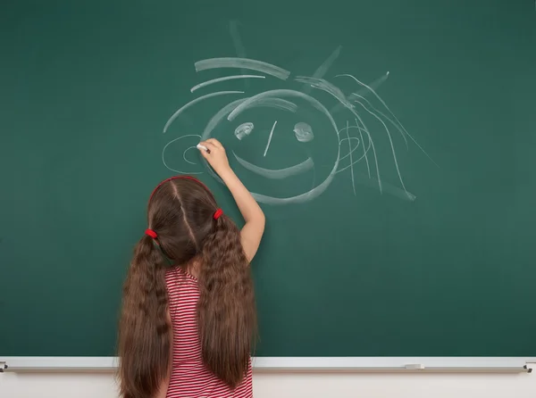 Mädchen zeichnet auf Schultafel — Stockfoto