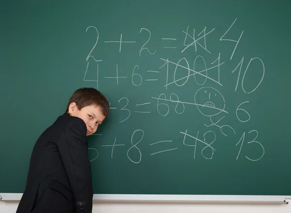 Menino da escola resolver matemática no conselho da escola — Fotografia de Stock