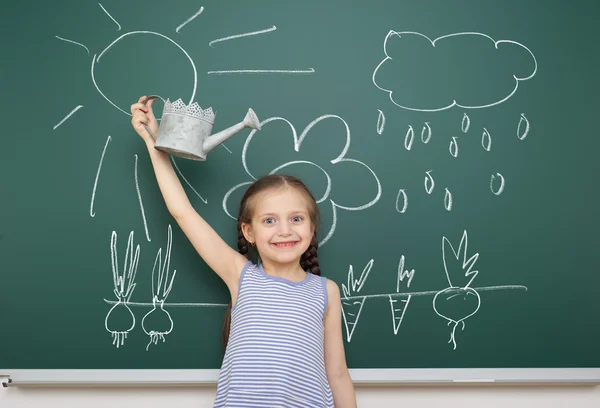 Mädchen mit Gießkanne zeichnet auf Schultafel — Stockfoto