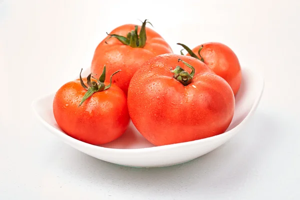 Tomatoes in plate on white — Stock Photo, Image