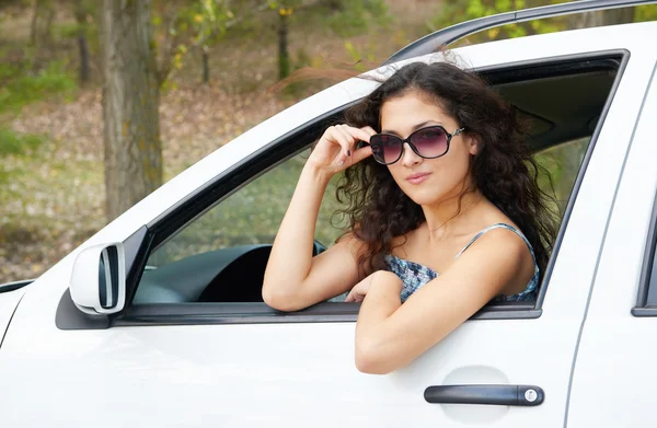 Chica conductor retrato con gafas de sol dentro de coche — Foto de Stock