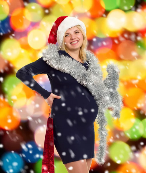 Schwangere Frau mit Weihnachtsmütze auf weihnachtlichem Hintergrund — Stockfoto