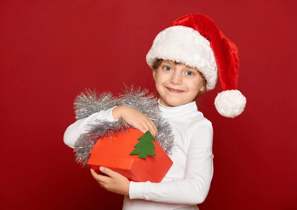 冬、子、クリスマス コンセプト - 赤のボックス ギフト ショー fir 木おもちゃでサンタの帽子でハッピー ガール — ストック写真