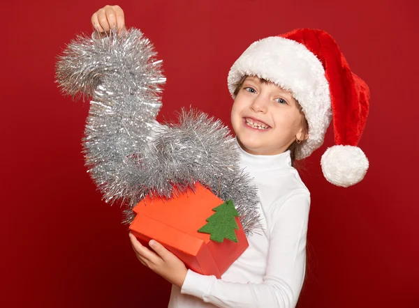 冬、子、クリスマス コンセプト - 赤のボックス ギフト ショー fir 木おもちゃでサンタの帽子でハッピー ガール — ストック写真