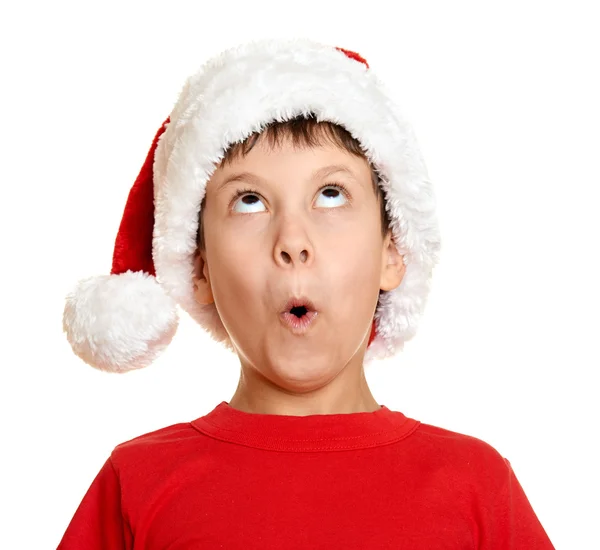 Winter holiday christmas concept - boy in santa hat look up on white isolated — 图库照片