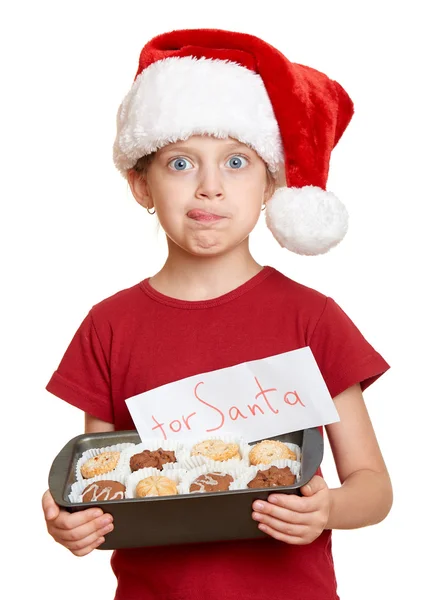 Κορίτσι με το καπέλο santa με μπισκότα γλείφουν τον εαυτό του - χειμερινών διακοπών Χριστουγέννων έννοια — Φωτογραφία Αρχείου