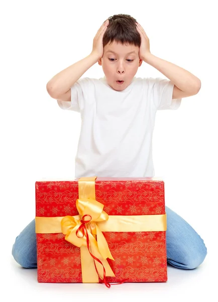Хлопчик з червоною подарунковою коробкою і золотим бантом концепція свята ізольована — стокове фото