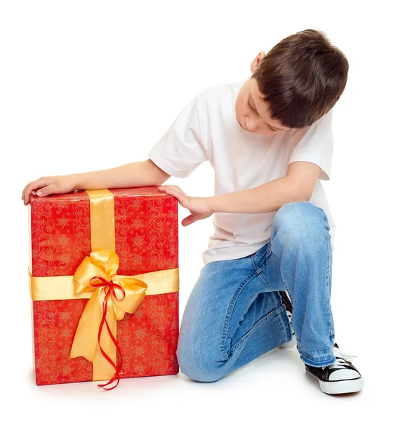 Niño con caja de regalo roja y arco dorado - concepto de objeto de vacaciones aislado —  Fotos de Stock