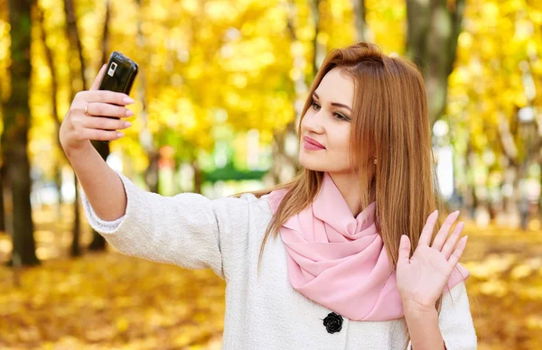 Kvinna med selfie i höst stadsparken — Stockfoto