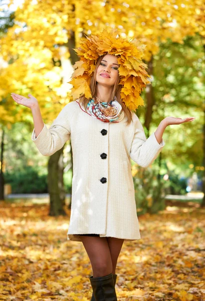 Женский портрет с листьями на голове в осеннем городском парке — стоковое фото