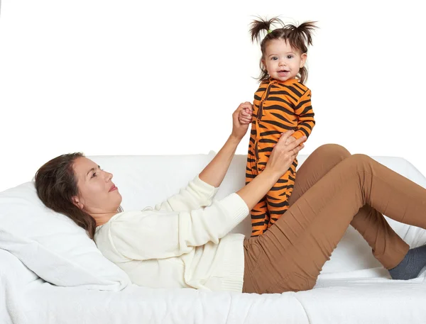 Woman with girl child portrait sitting on sofa and playing — Stock Photo, Image