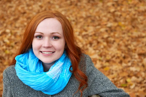 Rossa ragazza ritratto su arancio foglie sfondo — Foto Stock