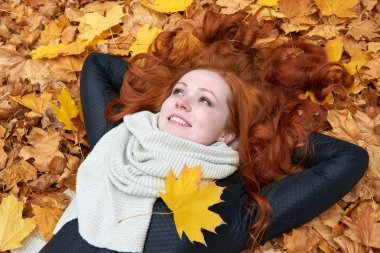 Kızıl saçlı kız yatan şehir park, Sonbahar sezonu bırakır.