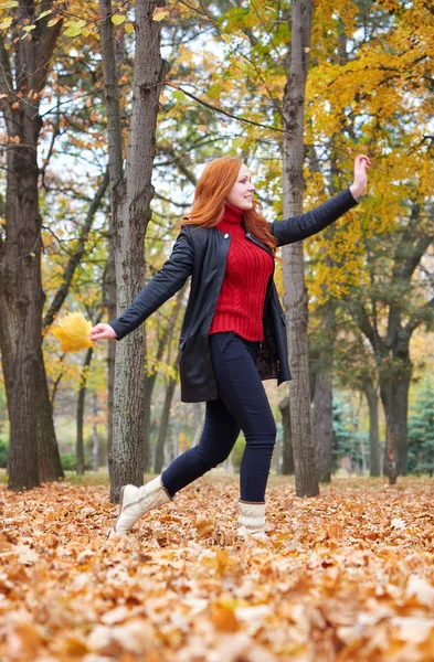 Menina ruiva executado com buquê de folhas no parque da cidade, temporada de outono — Fotografia de Stock