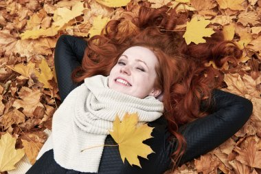 Kızıl saçlı kız yatan şehir park, Sonbahar sezonu bırakır.