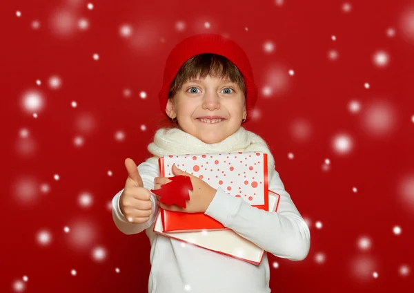 Heureux fille dans santa chapeau avec boîte cadeau spectacle sapin laine jouet sur rouge hiver, enfant, Noël concept — Photo