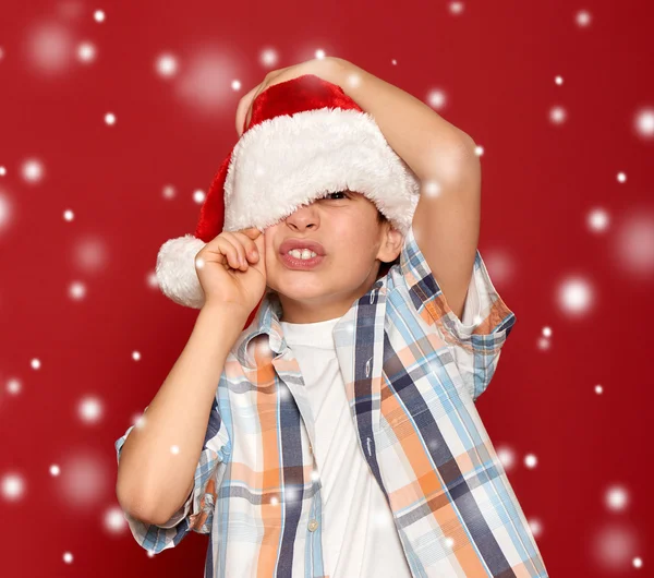 Зимові канікули різдвяна концепція хлопчик в капелюсі Санта закрити одне око — стокове фото