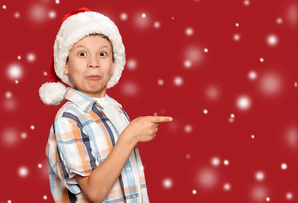 Noël concept vacances d'hiver - garçon dans santa chapeau point son fi — Photo