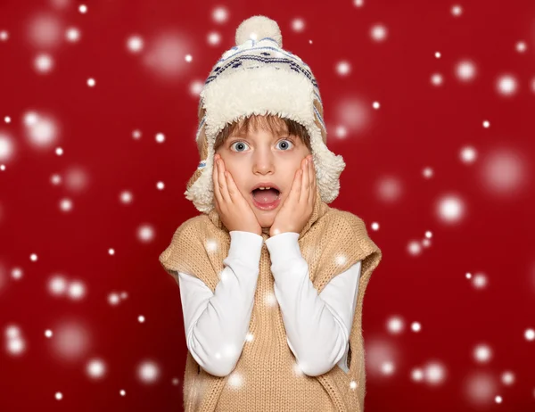 Conceito de férias de inverno - menina em chapéu e suéter em backgrou vermelho — Fotografia de Stock